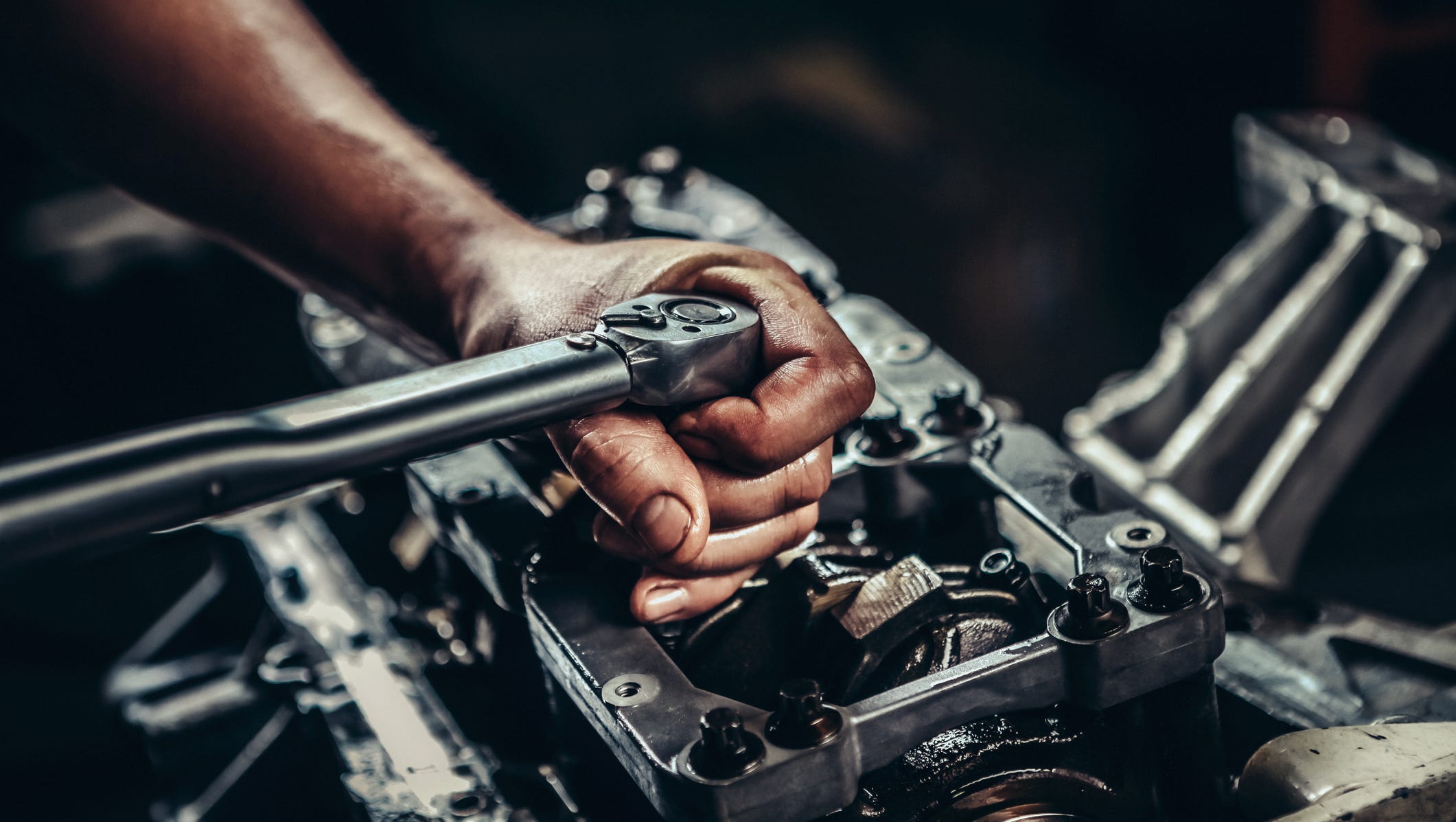 Auto Parts & Accessories template hero — mechanic tightening bolts on engine block